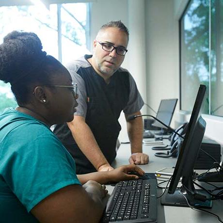 两个护理专业的研究生在模拟实验室的电脑上工作